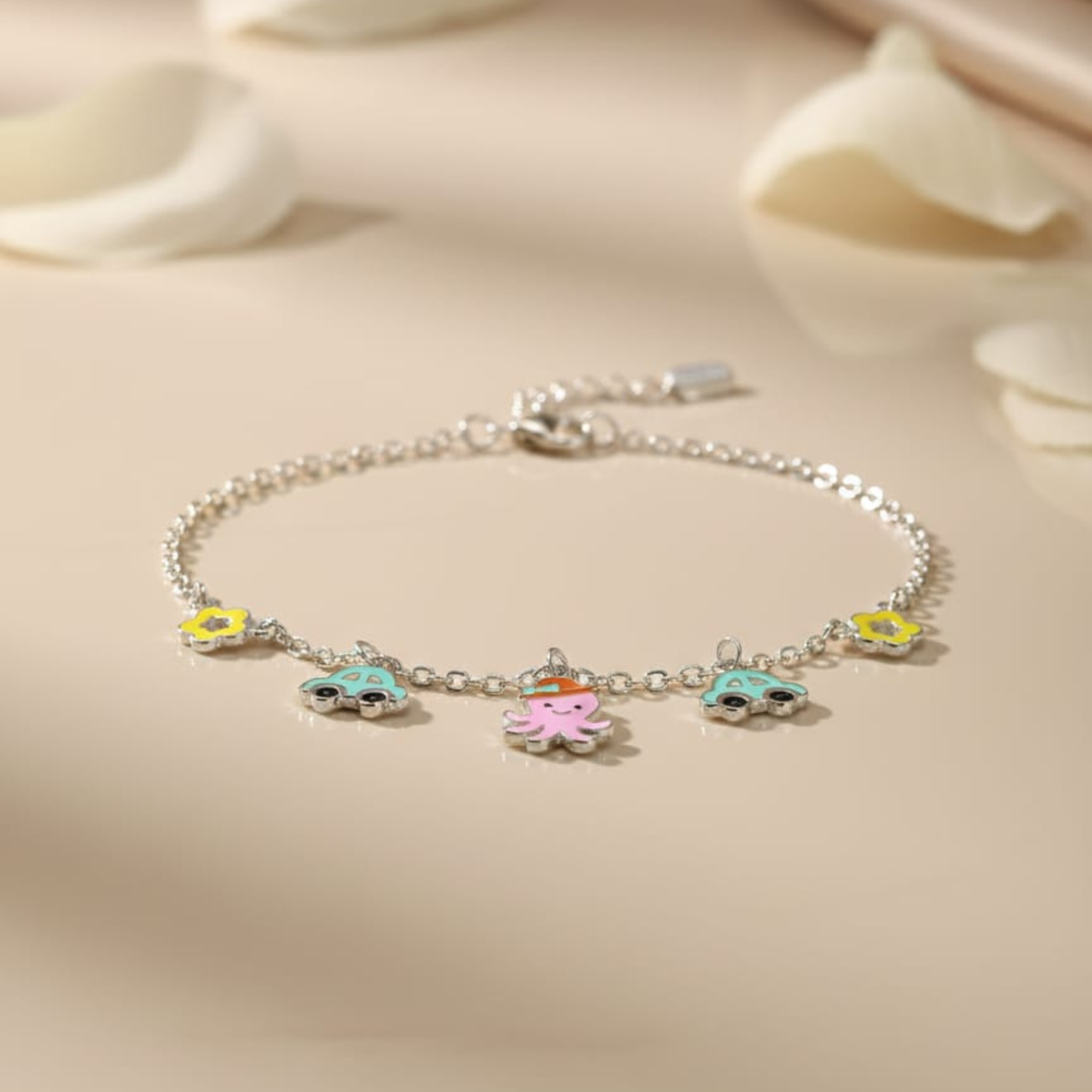 Silver bracelet with colorful charms on a beige background