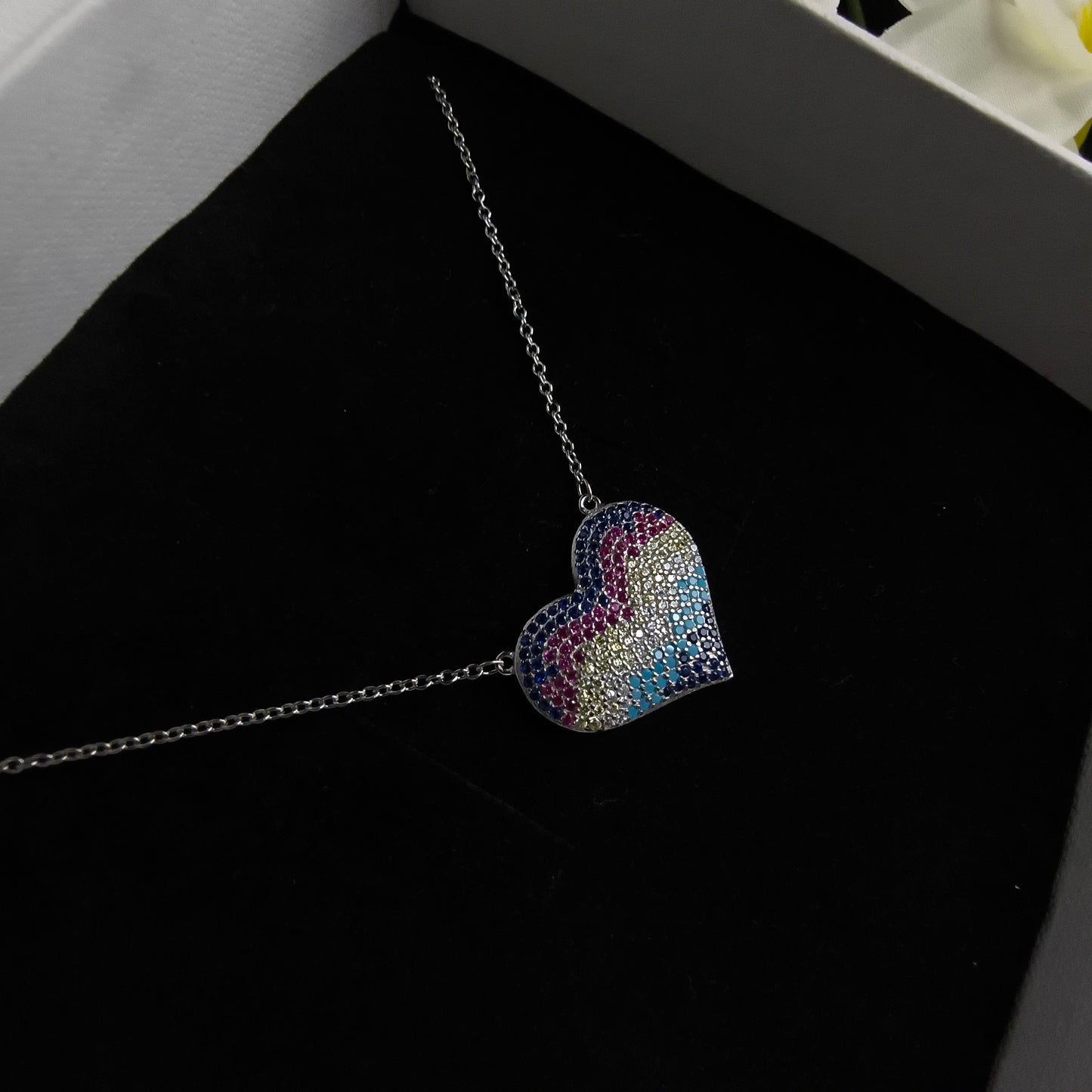 Multicolored heart-shaped brooch on a dark background