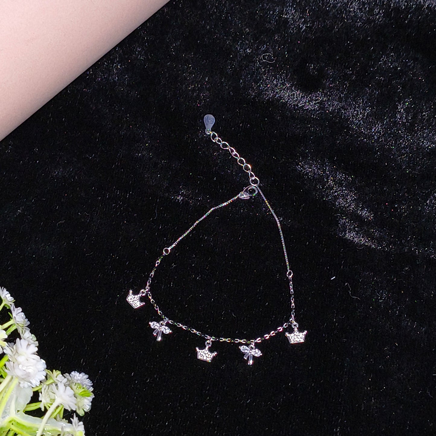 Silver bracelet with floral designs on a black background