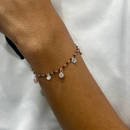 Bracelet with small charms on a wrist against a white background