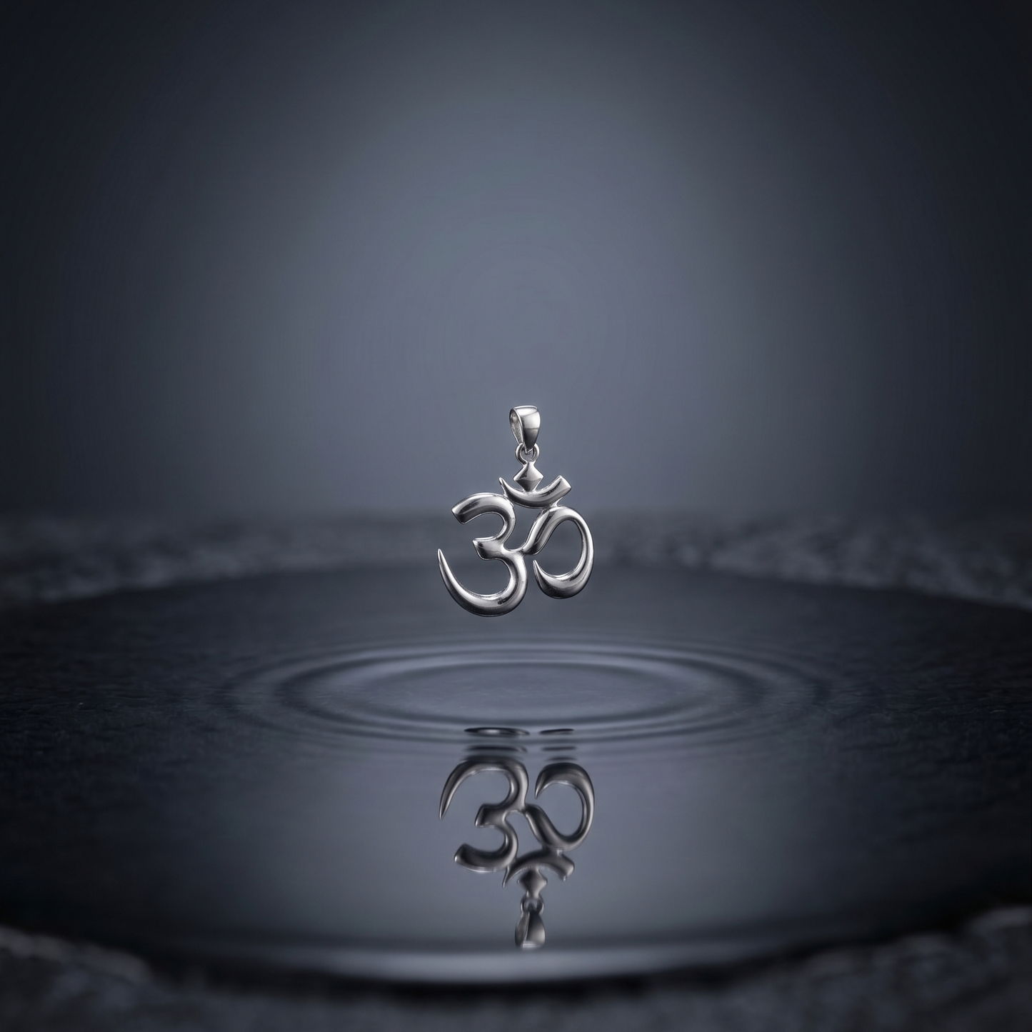 Silver pendant with Om symbol on water surface