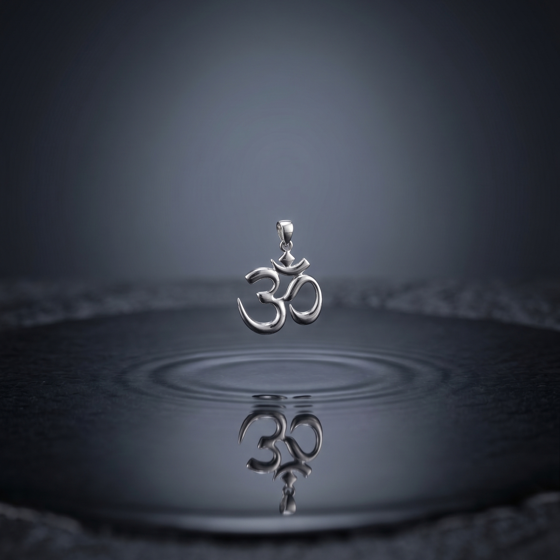 Silver pendant with Om symbol on water surface