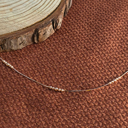 Close-up of a beaded necklace on a brown textured fabric background