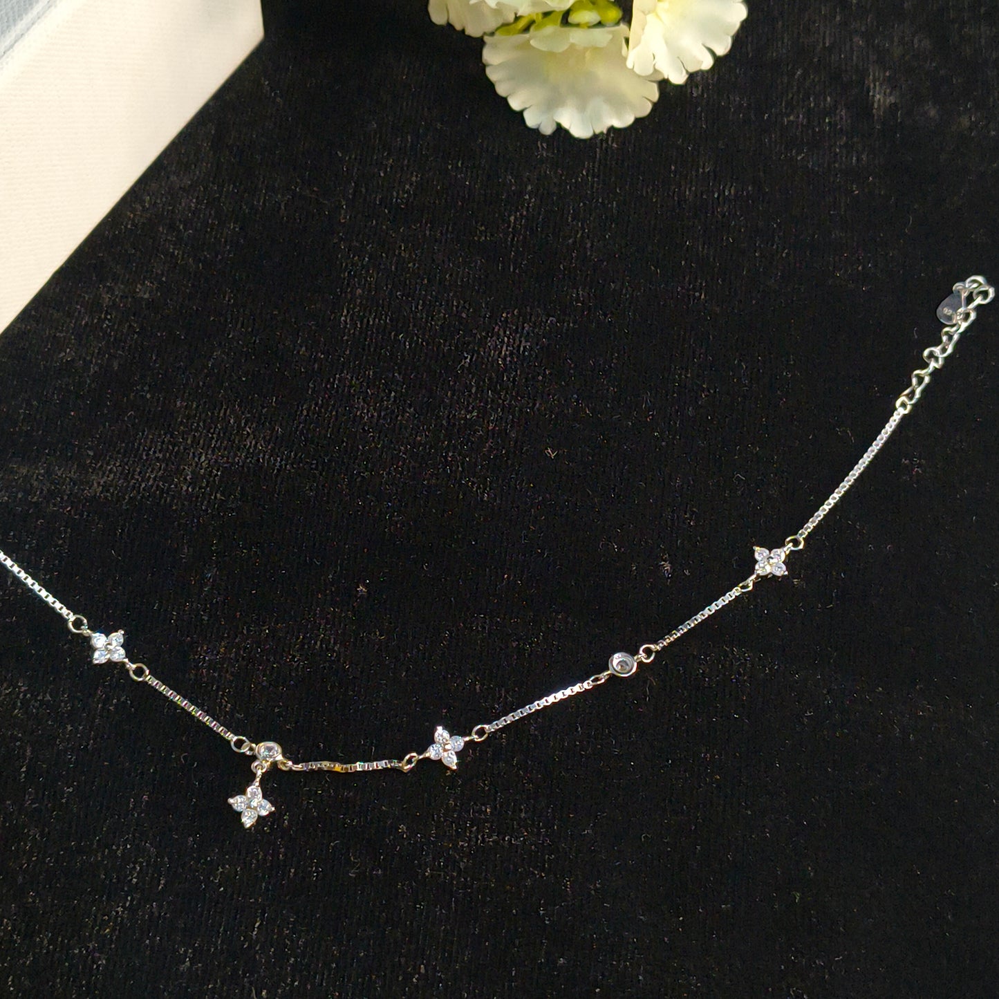 Silver necklace with star-shaped pendants on a black background