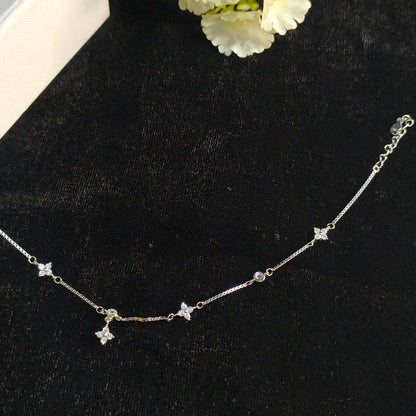 Silver necklace with star-shaped pendants on a black background