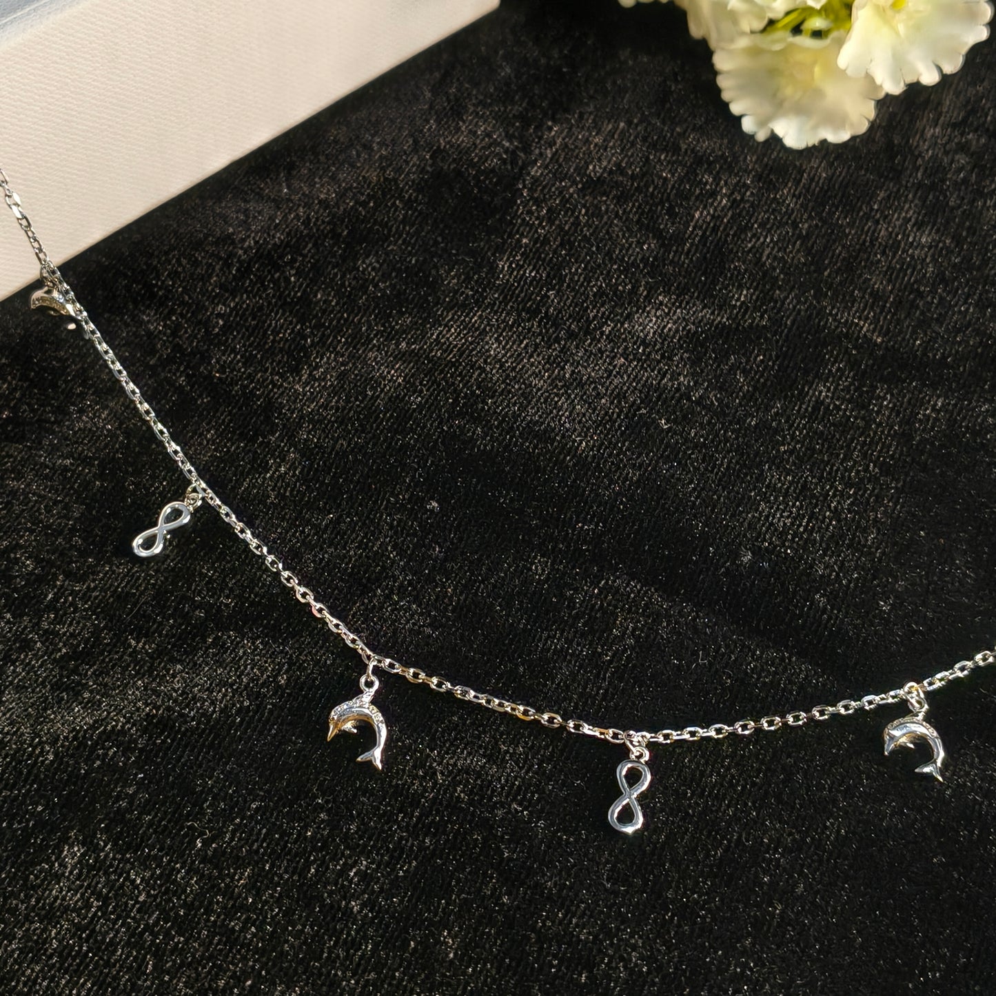 Silver bracelet with charms on a black surface