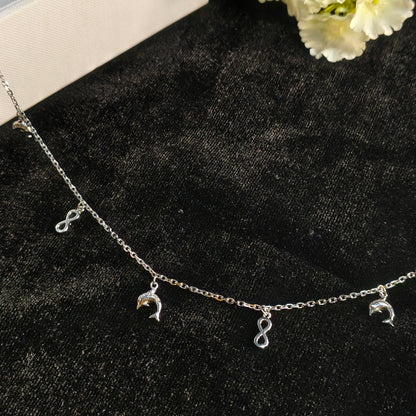 Silver bracelet with charms on a black surface