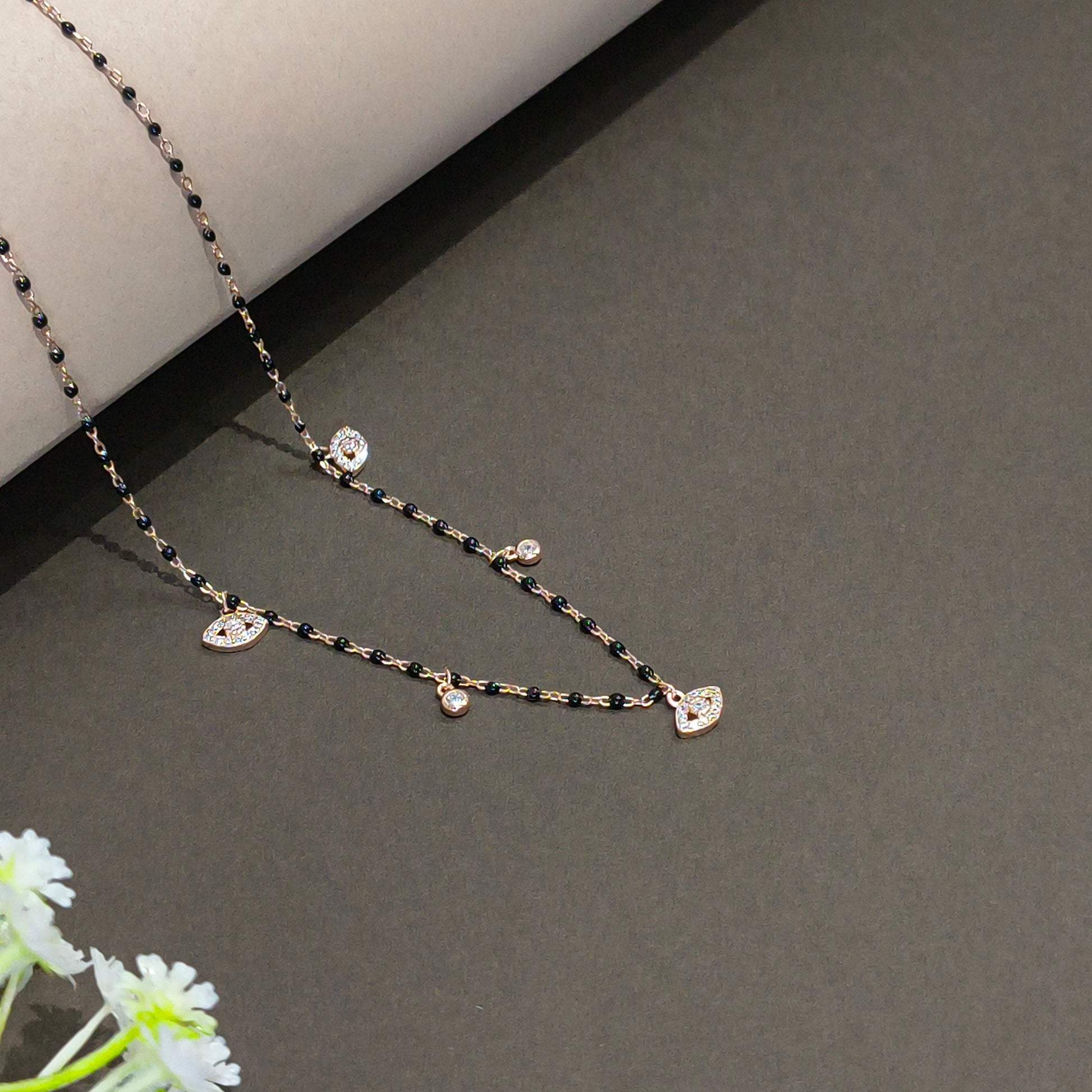 Delicate necklace with small stones on a gray background