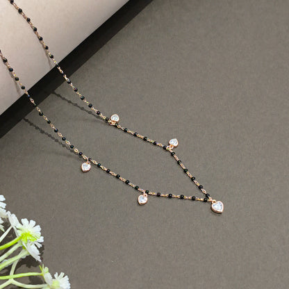 Delicate necklace with black and gold chain on a gray background