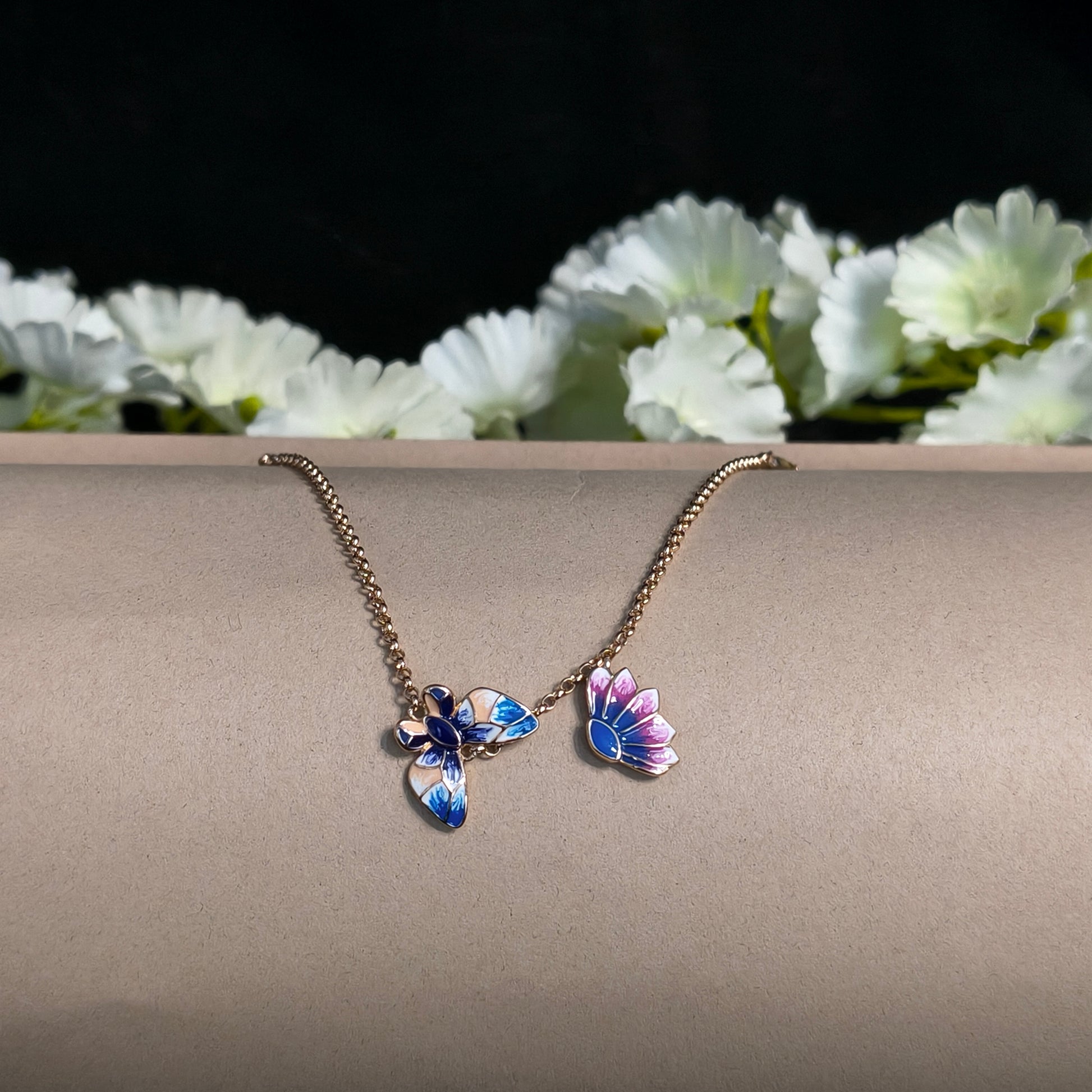 Butterfly-shaped earring on a stand with white flowers in the background
