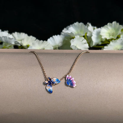 Butterfly-shaped earring on a stand with white flowers in the background