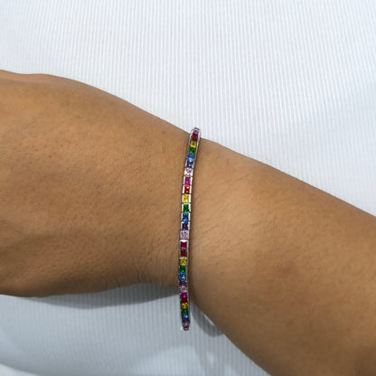 Multicolored beaded bracelet on a wrist against a white background