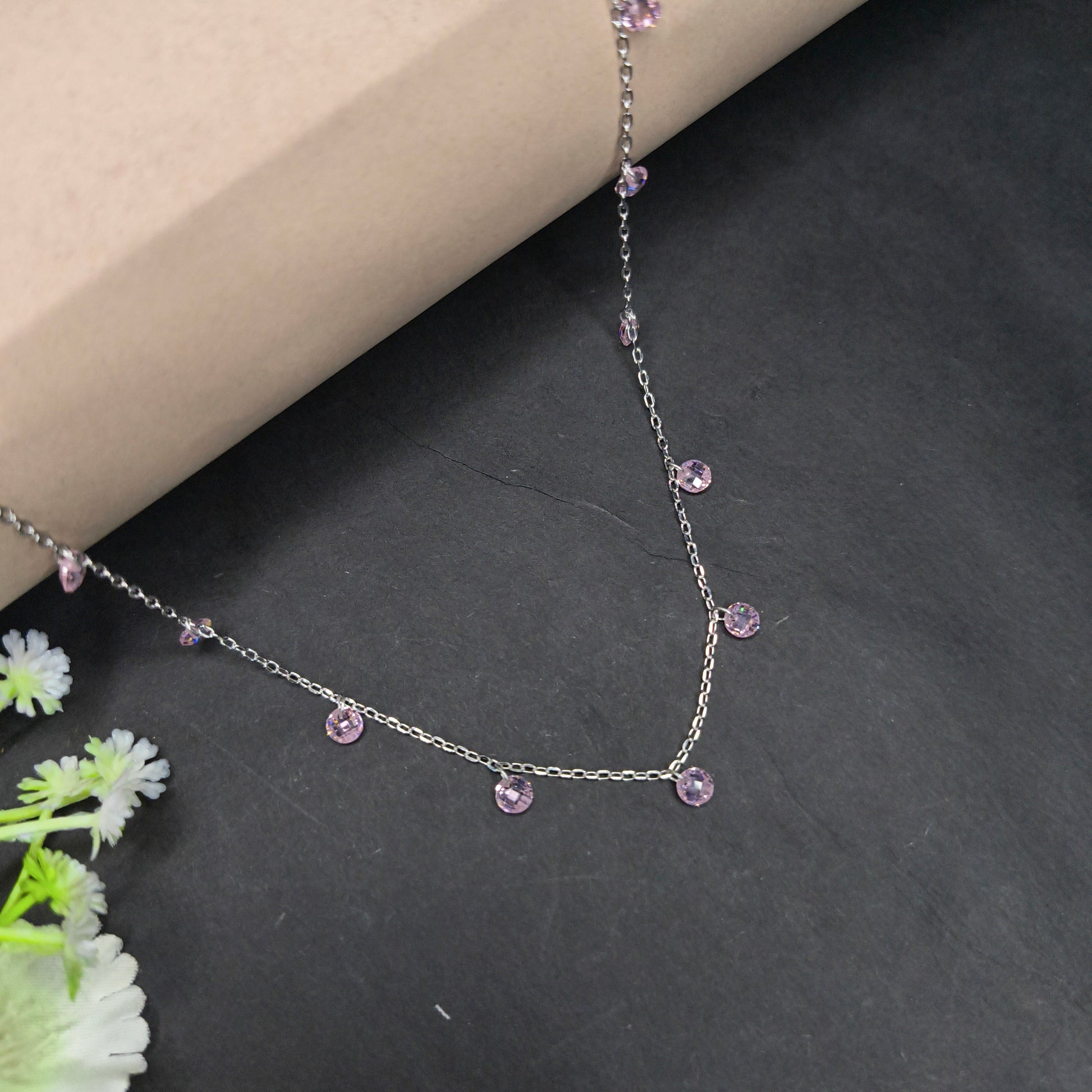 Necklace with pink gemstones on a dark surface