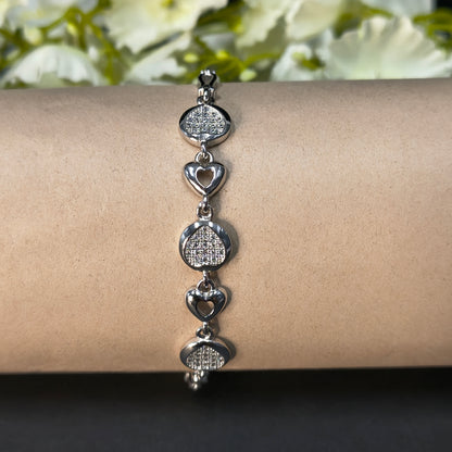 Silver bracelet on a wrist with a blurred floral background