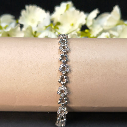 Silver bracelet on a mannequin arm with a floral background