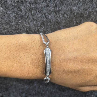 Silver bracelet on a wrist against a dark textured background