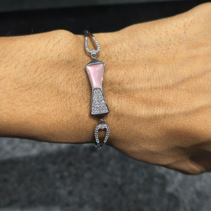 Bracelet with bow design on a wrist against a dark background