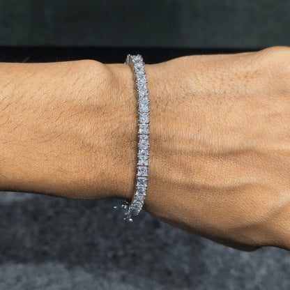 Diamond bracelet on a wrist against a dark background