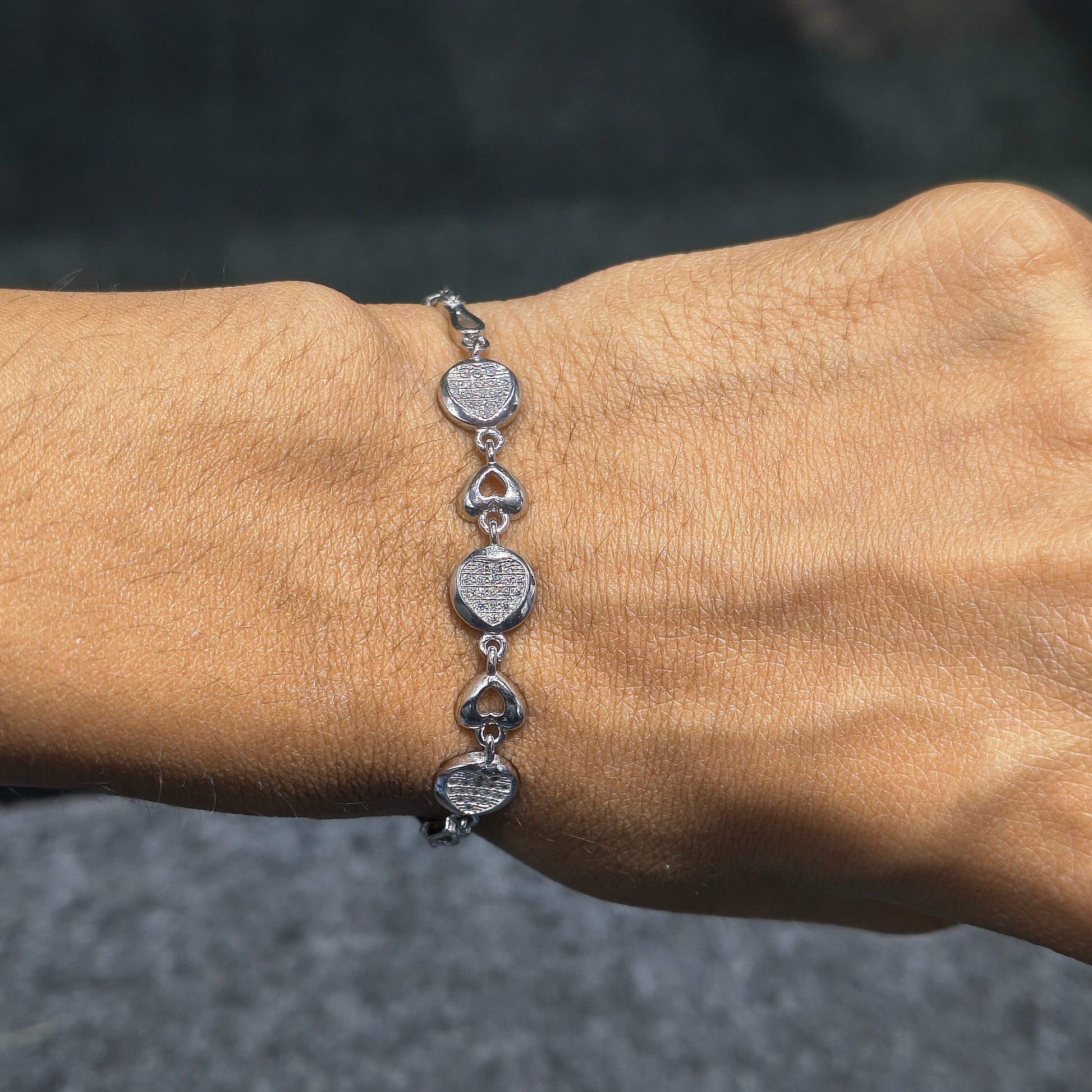 Silver bracelet on a wrist with a blurred background
