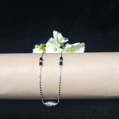 Silver bracelet with white flowers on a black background