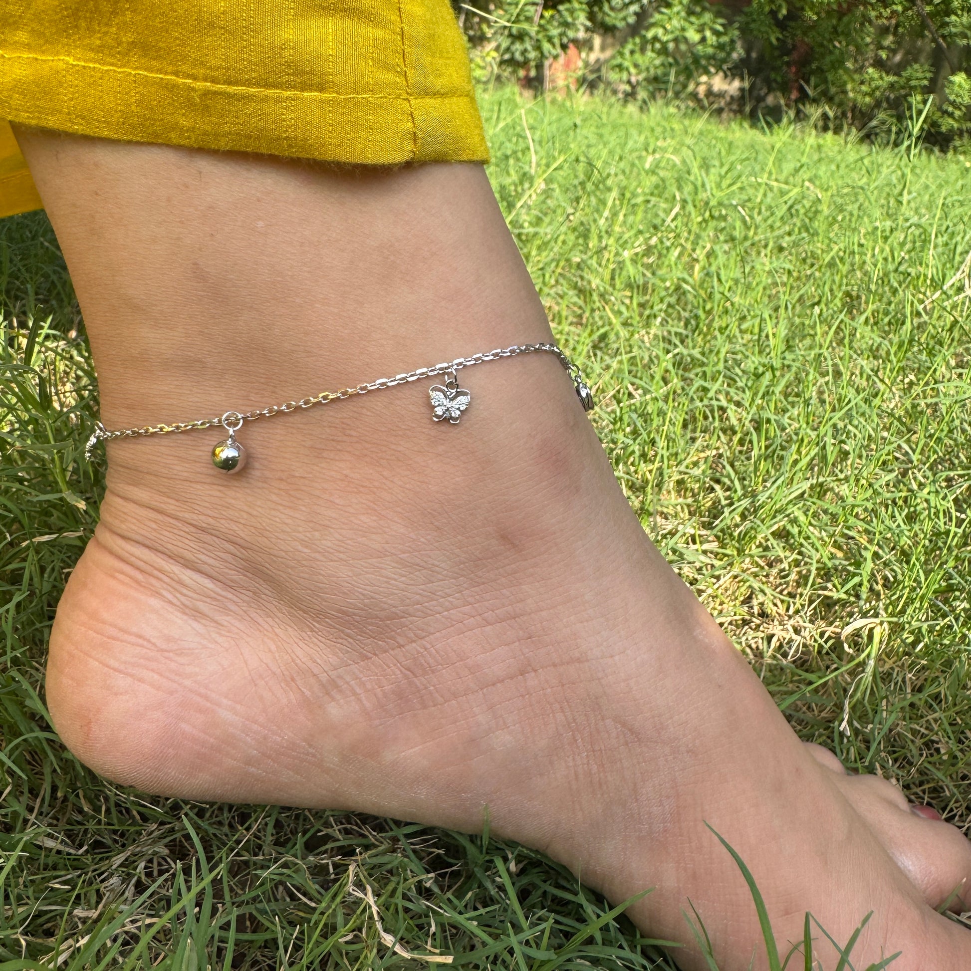 Ankle with silver anklets on grass