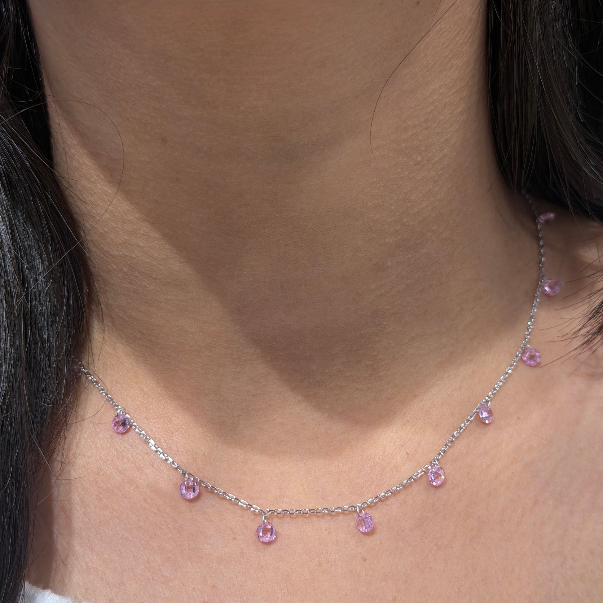 Necklace with pink gemstones worn by a person