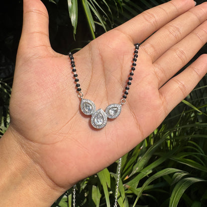 Necklace with a pendant held in a hand against a natural background