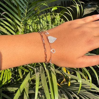 Hand wearing a bracelet with a leafy green background