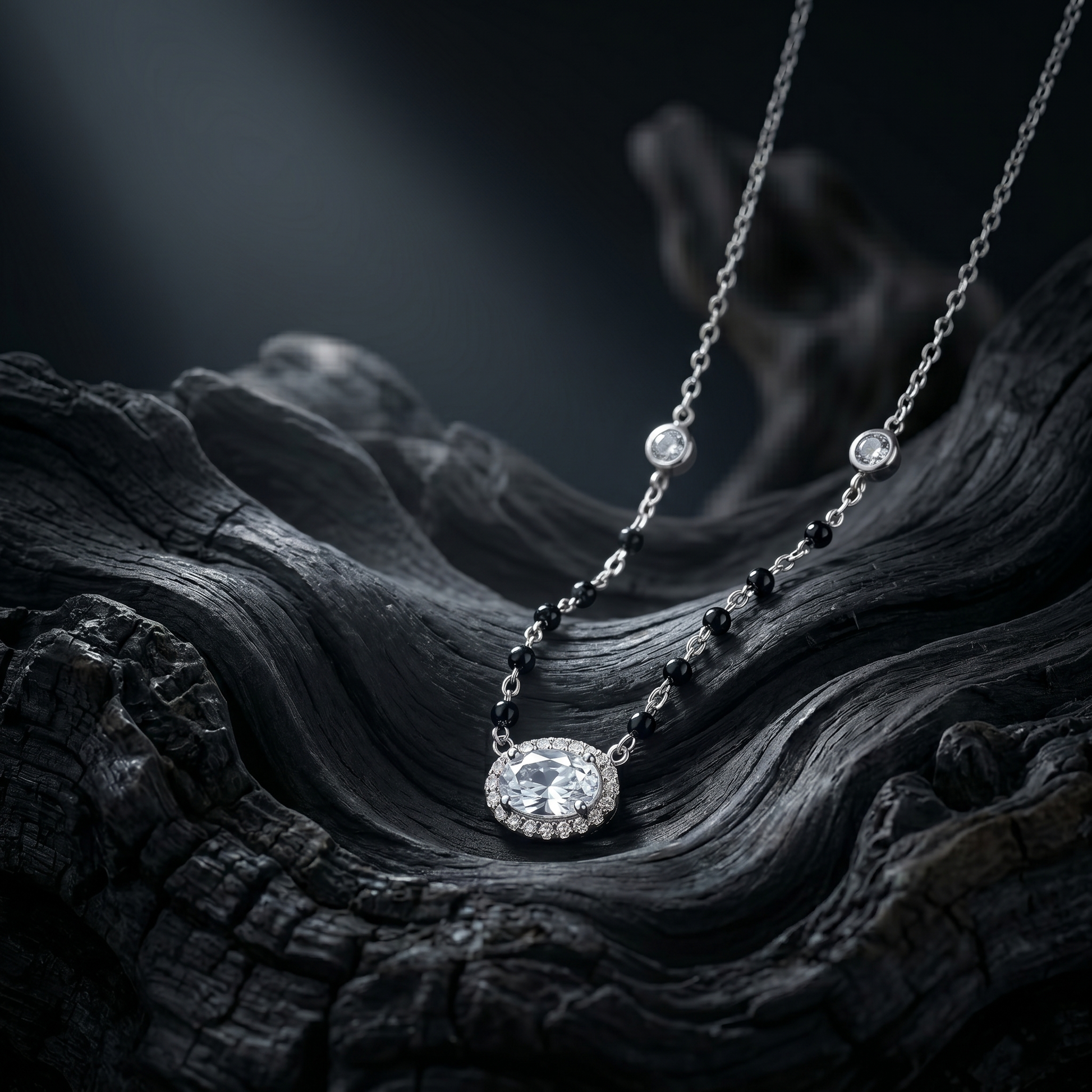 Silver necklace with a pendant on a dark, textured surface