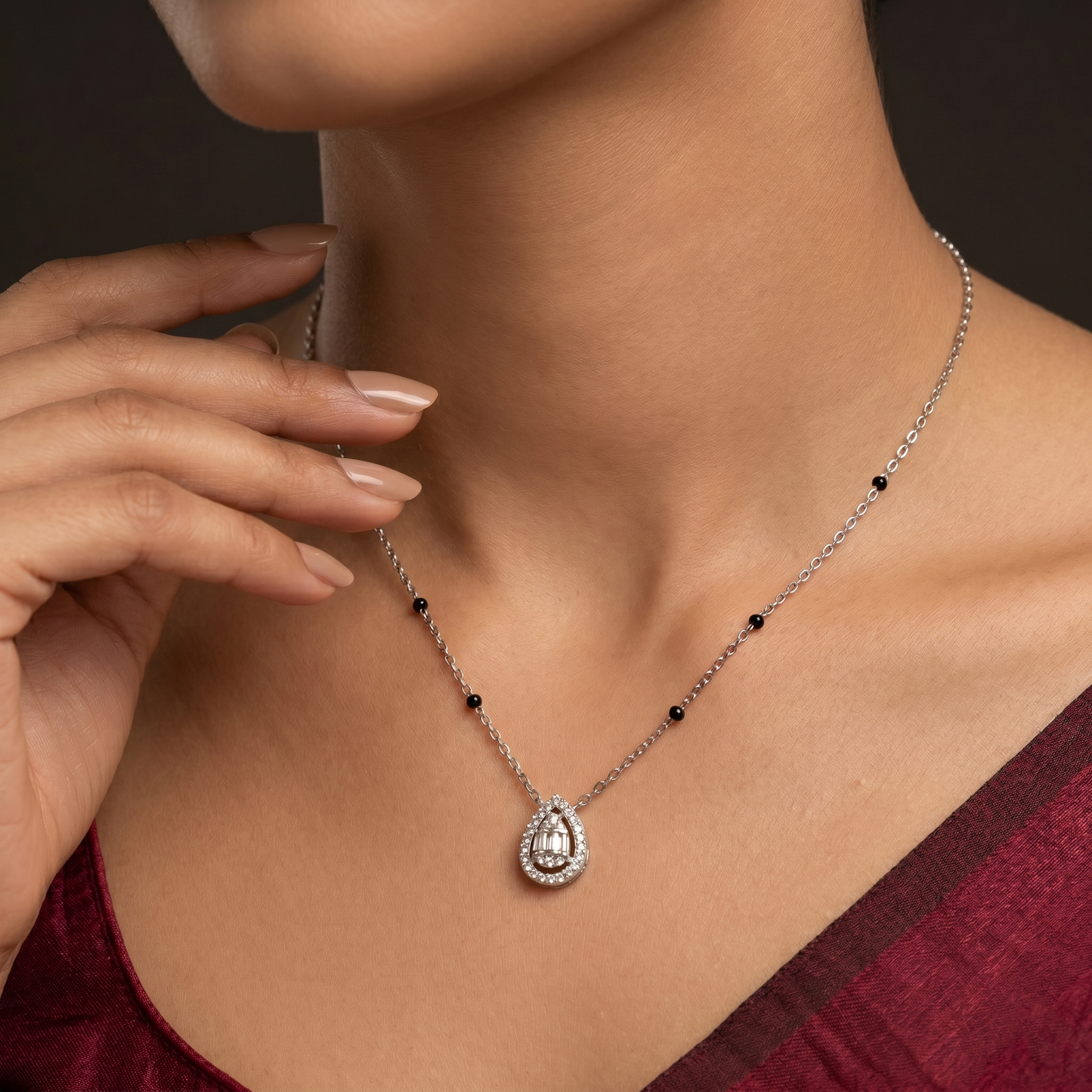 Necklace with a pendant worn by a person, against a neutral background