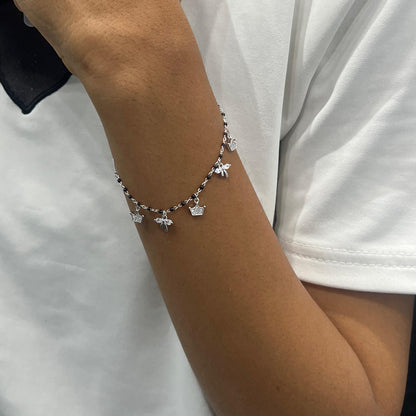 Bracelet with charms on a wrist against a white background