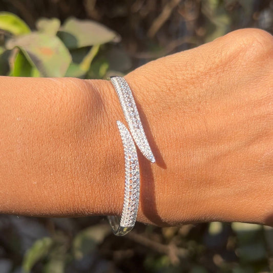 Silver bracelet on a wrist with a blurred natural background