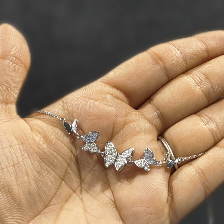 Silver butterfly bracelet on a hand with a blurred background