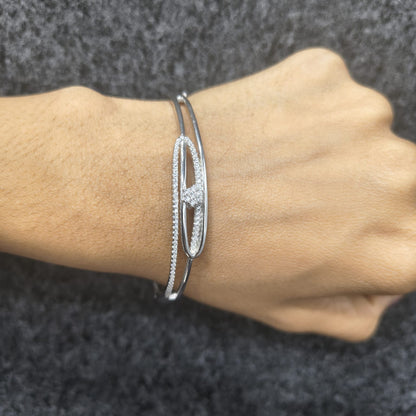 Silver bracelet on a wrist against a dark textured background