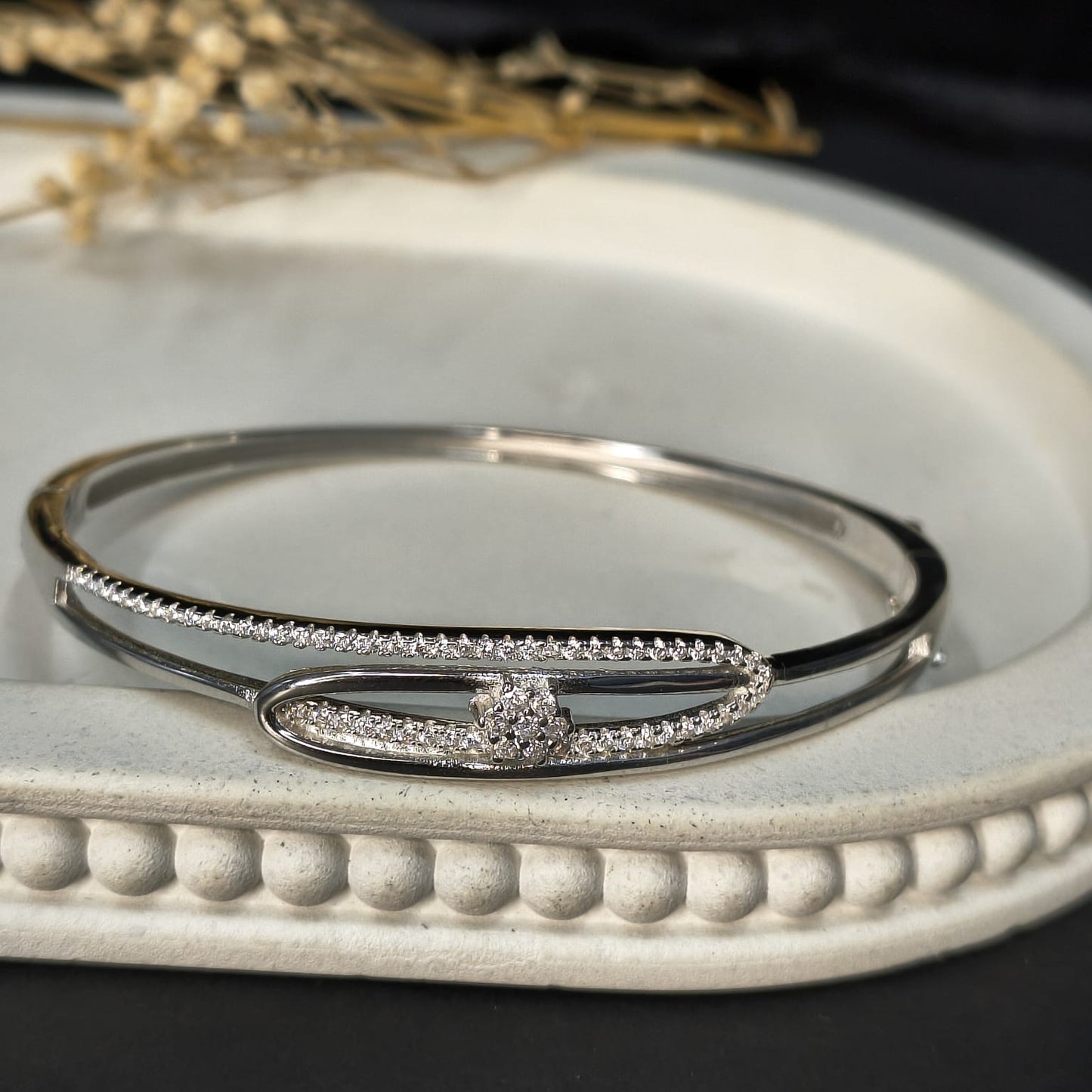 Silver bracelet with gemstones on a decorative white surface