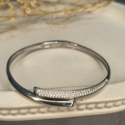 Silver bracelet with diamond accents on a textured surface