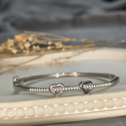 Silver bracelet with heart designs on a textured surface