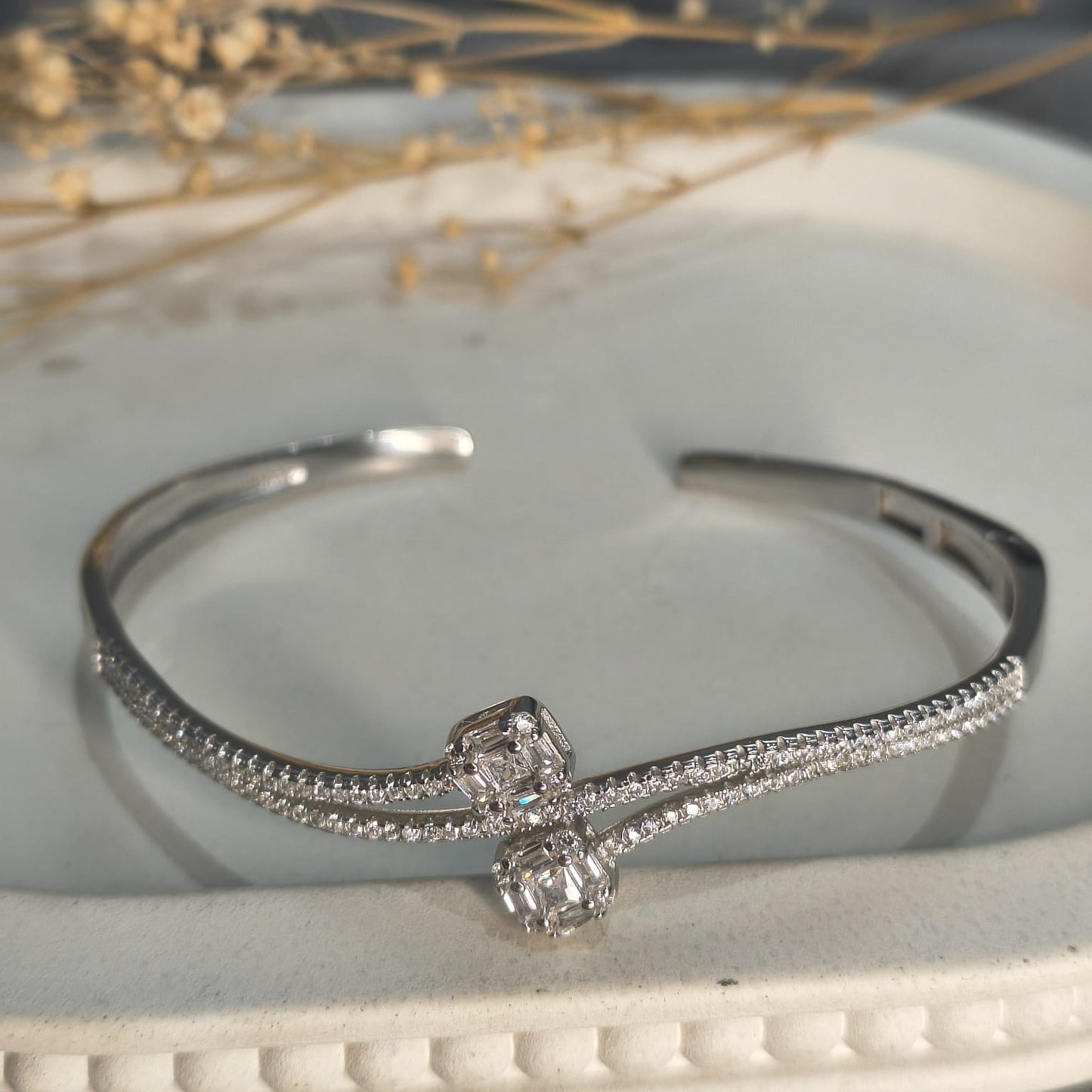 Silver bracelet with diamond accents on a white surface