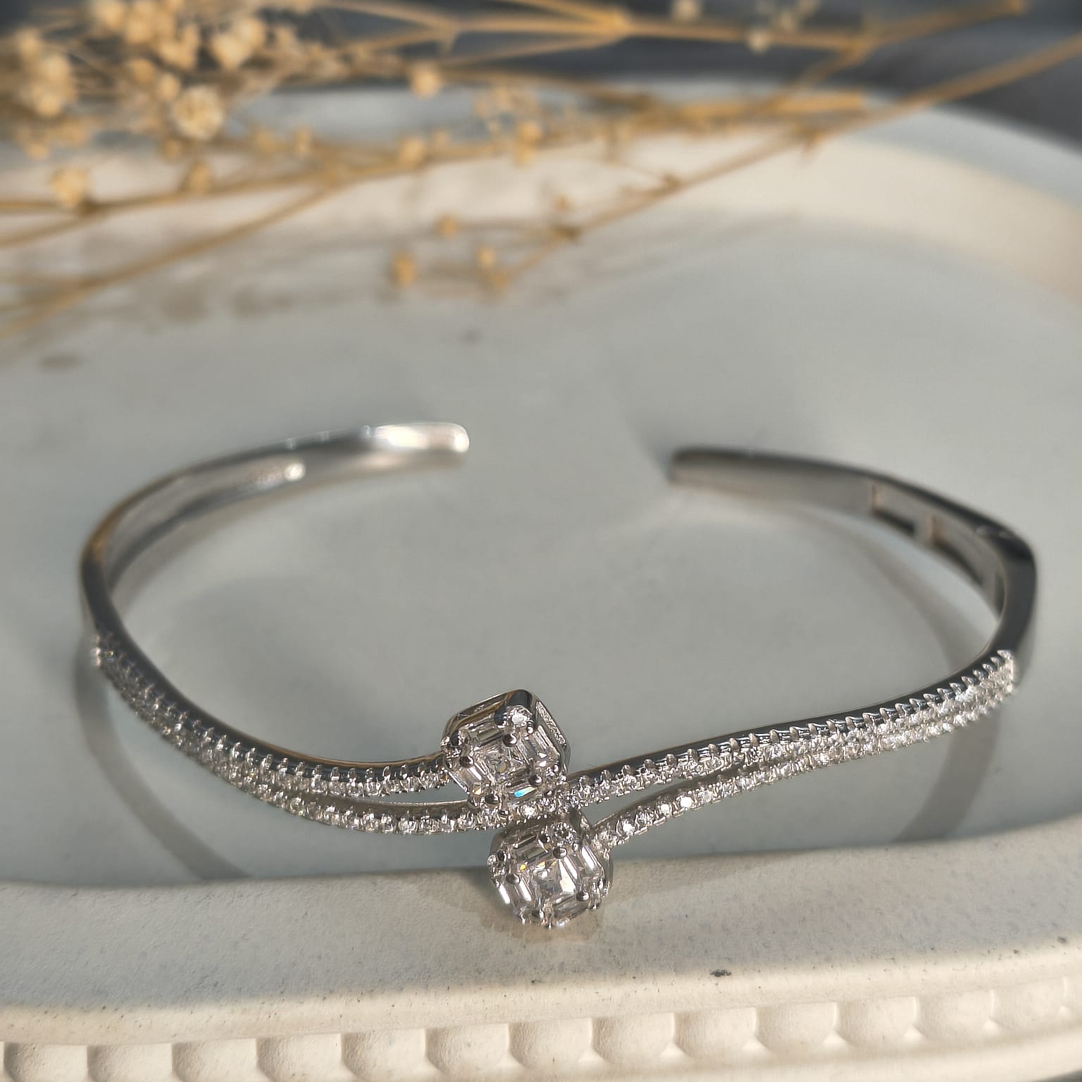 Silver bracelet with diamond accents on a white surface