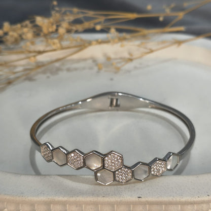 Silver bracelet with honeycomb pattern on a textured surface