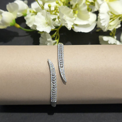 Silver hoop earrings on a beige cushion with white flowers in the background