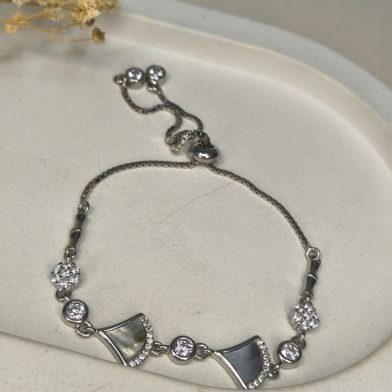 Silver bracelet with decorative elements on a light background