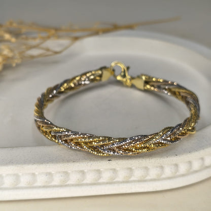 Gold and silver braided bracelet on a white surface
