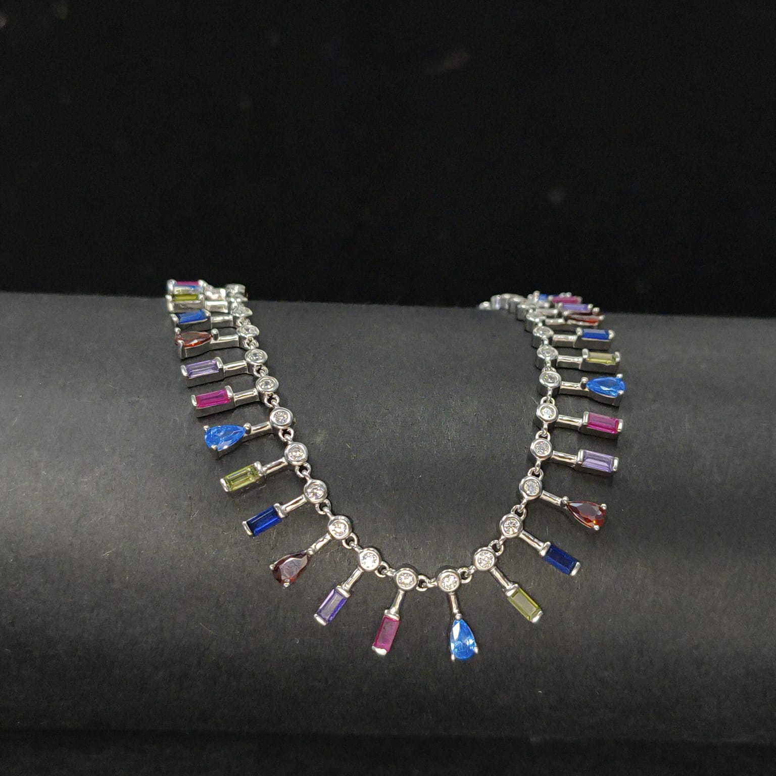 Necklace with multicolored gemstones on a dark surface