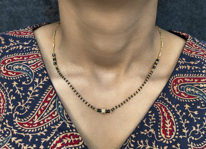 Necklace on a person wearing a patterned garment