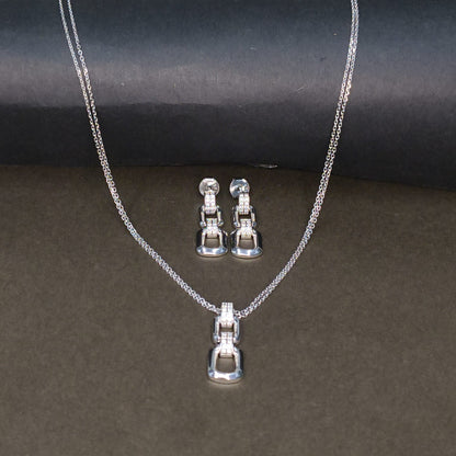 Silver necklace and earrings set on a dark background