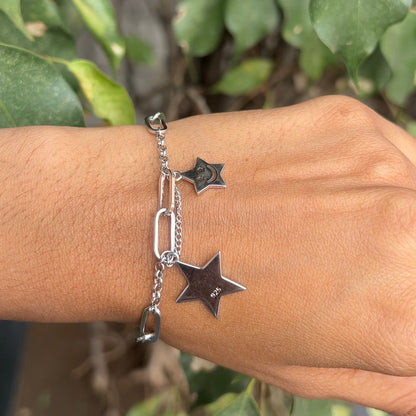 Silver star bracelet on a wrist with a natural background