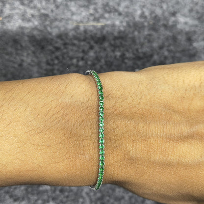Green bracelet on a wrist with a gray textured background