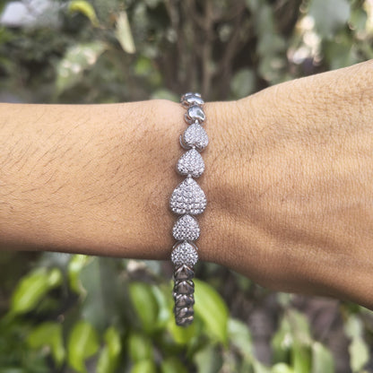 Silver bracelet on a wrist with a blurred green background