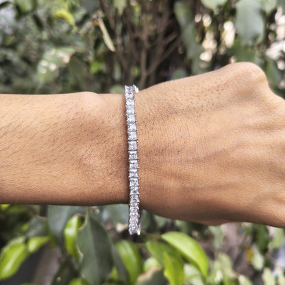 Diamond bracelet on a wrist with a blurred green leafy background